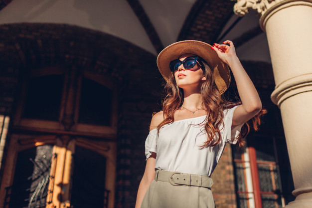 Fashion model. outdoor portrait of tourist woman enjoying sightseeing in lviv. girl looking at ancient atchitecture Premium Photo