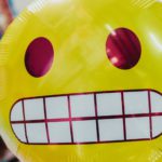 yellow inflatable smiling emoji balloon in focus photography