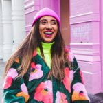 woman in white blue and red sweater wearing pink knit cap